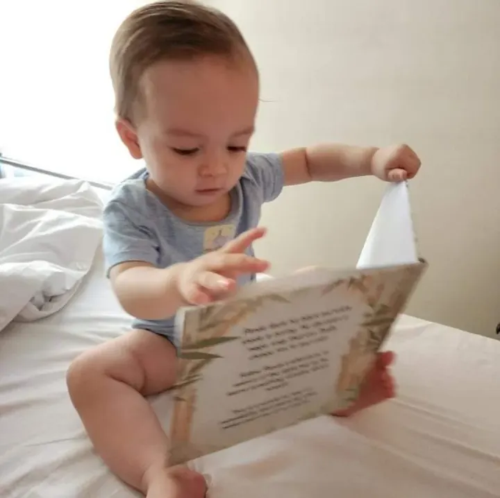 A baby turning the pages of the book