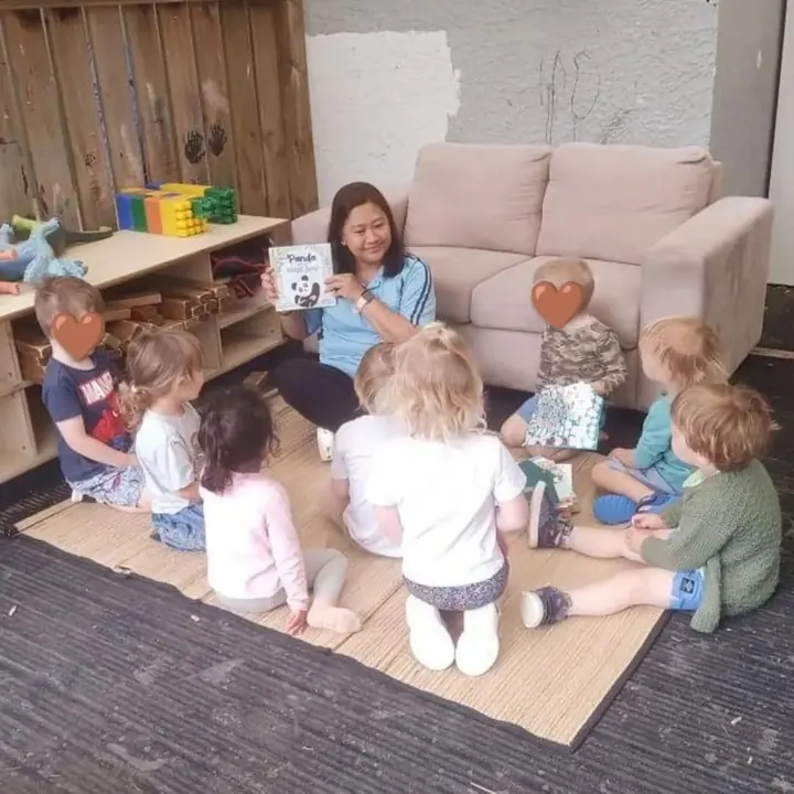 A teacher reading Panda to a circle of preschoolers in New Zealand